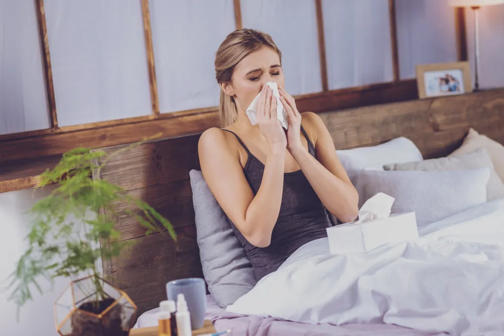 Woman sneezing on John Ryan mattress