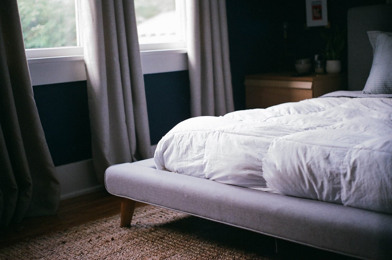 White bed with curtains open