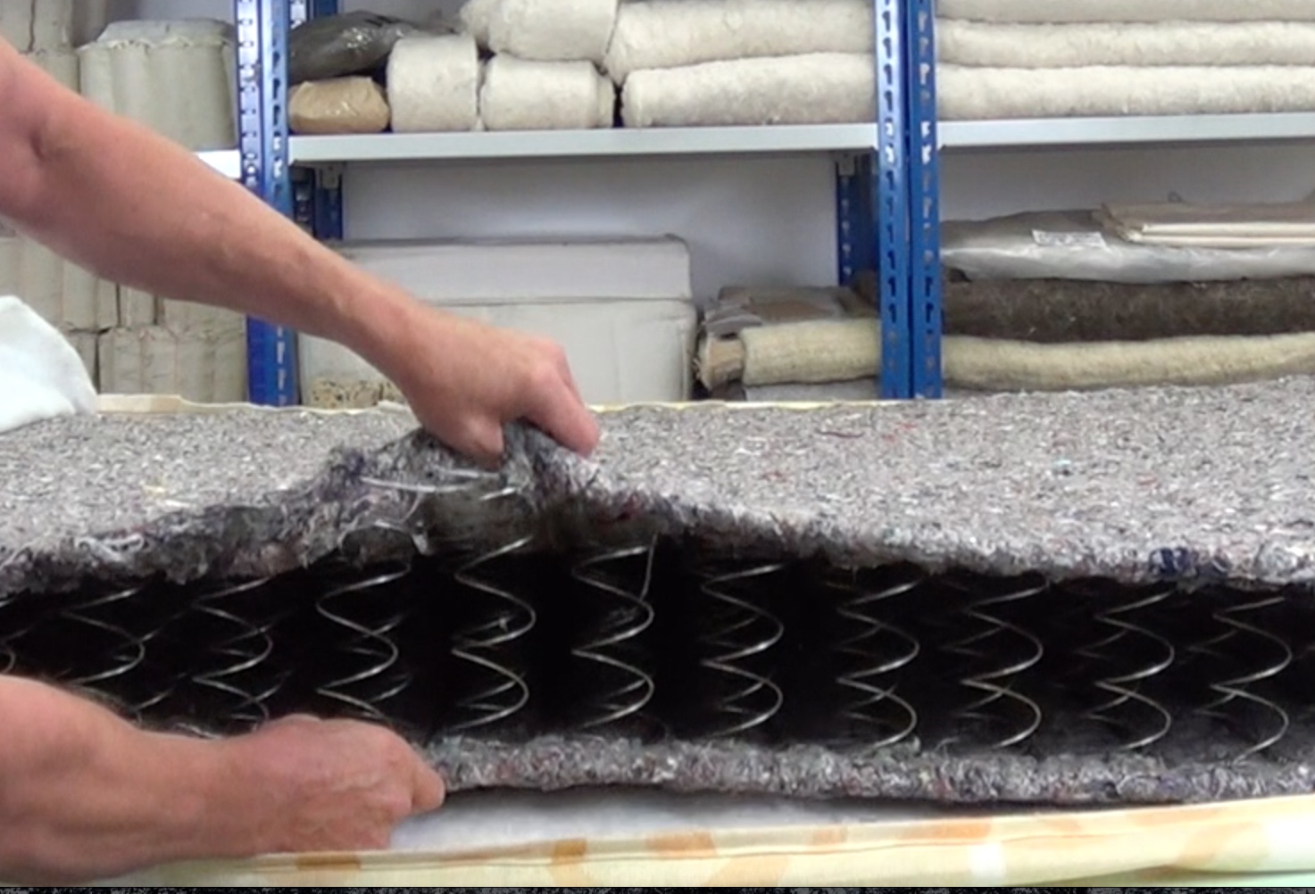 A man holding open a cage sprung mattress