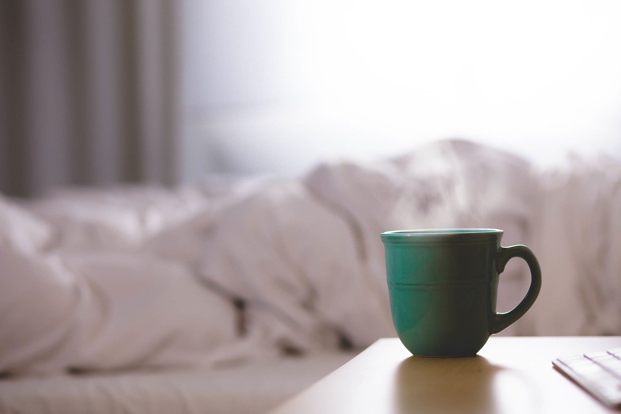 A green cup on a bedside table