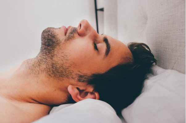 A man sleeping on his back, showing the level of support needed for the neck