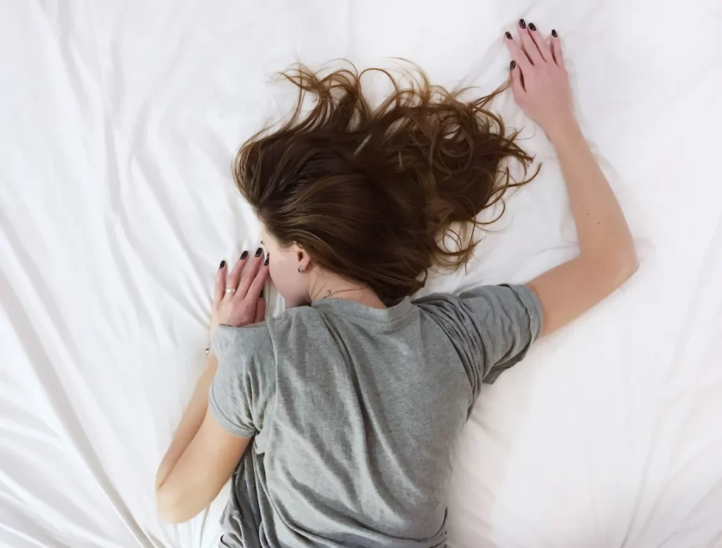 Woman lying in pain on a bed