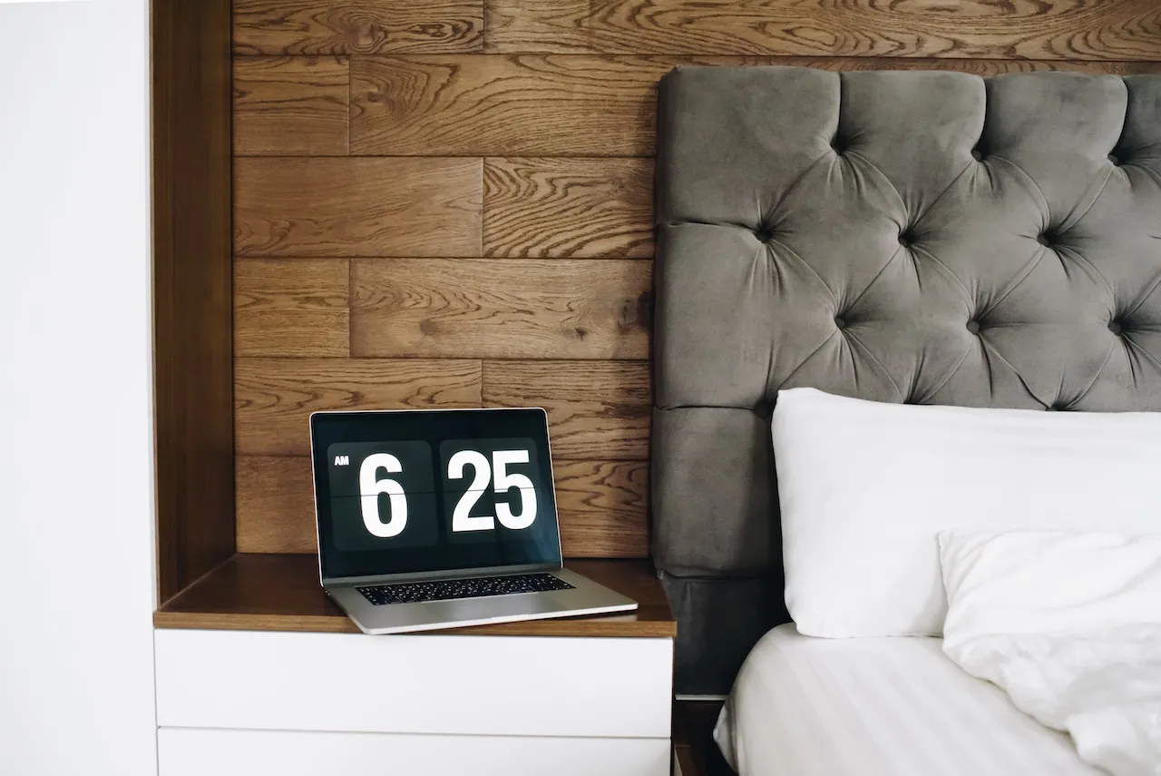 Grey buttoned upholstered headboard behind a bed