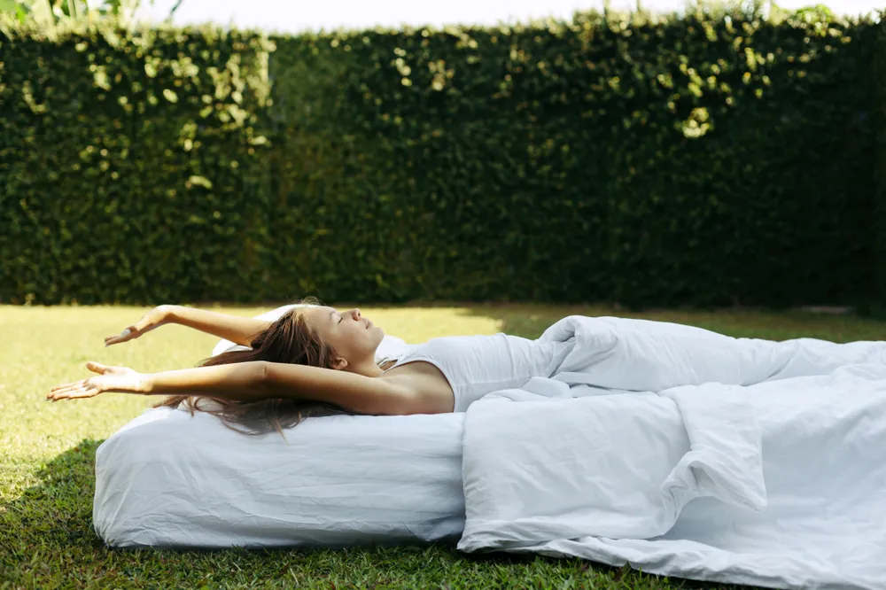 A woman sleeping outdoors on an organic mattress