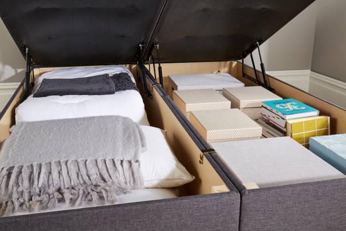 Details of books, bedding and boxes stored in a John Ryan Ottoman "charcoal bracken" bed base