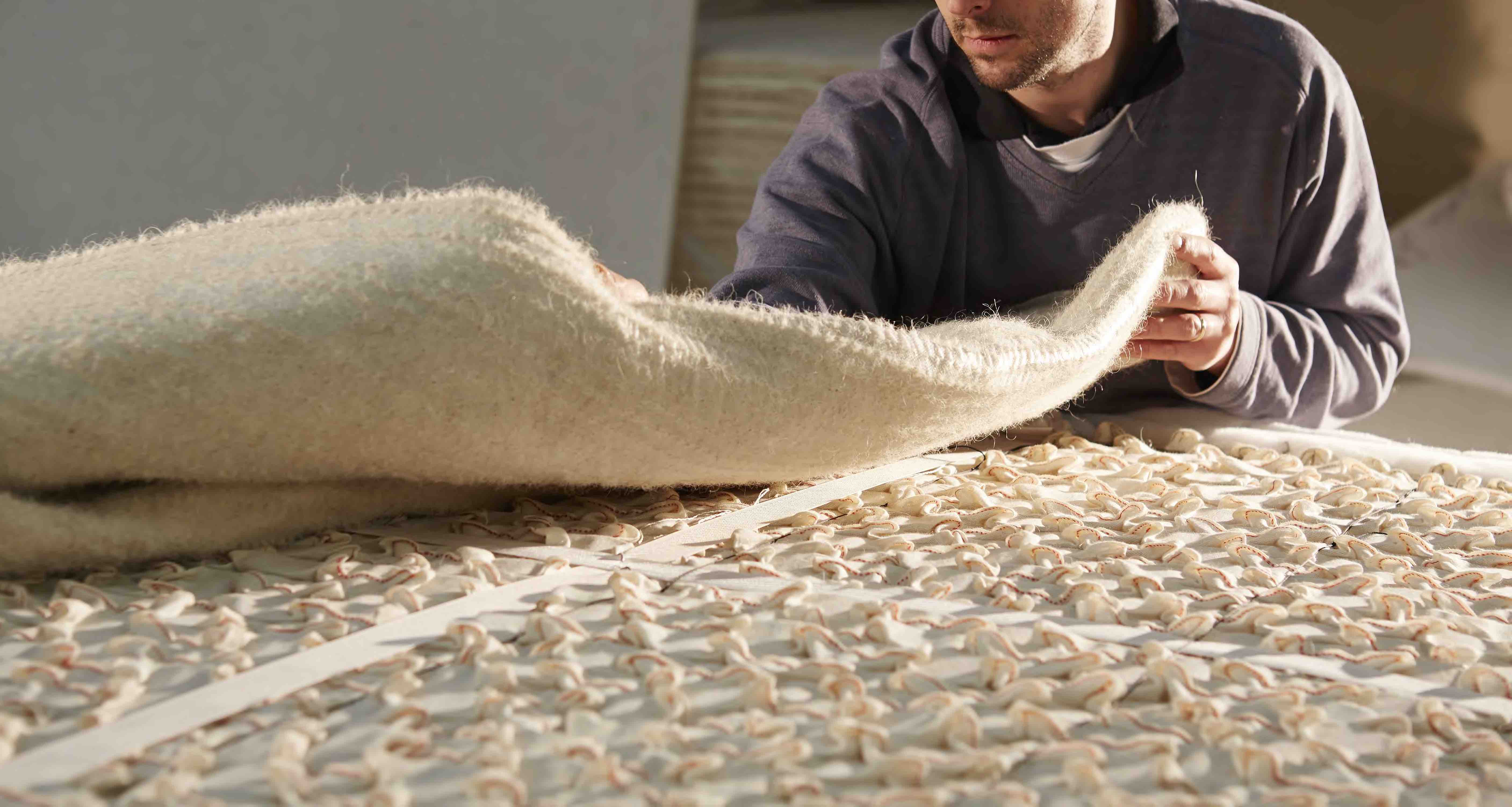Applying the insulator layer of a natural fibre mattress